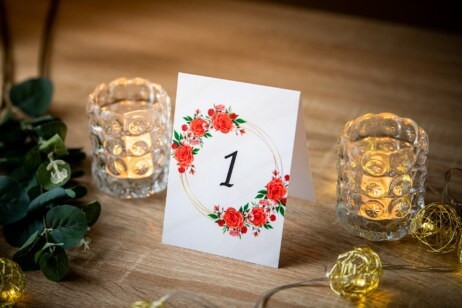 Numer stołu ze złotym okręgiem i czerwonymi różami