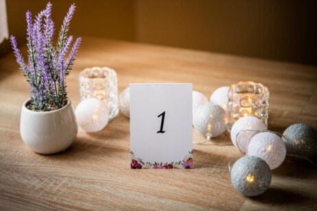 Numerek stolika  z fioletową kompozycja kwiatową